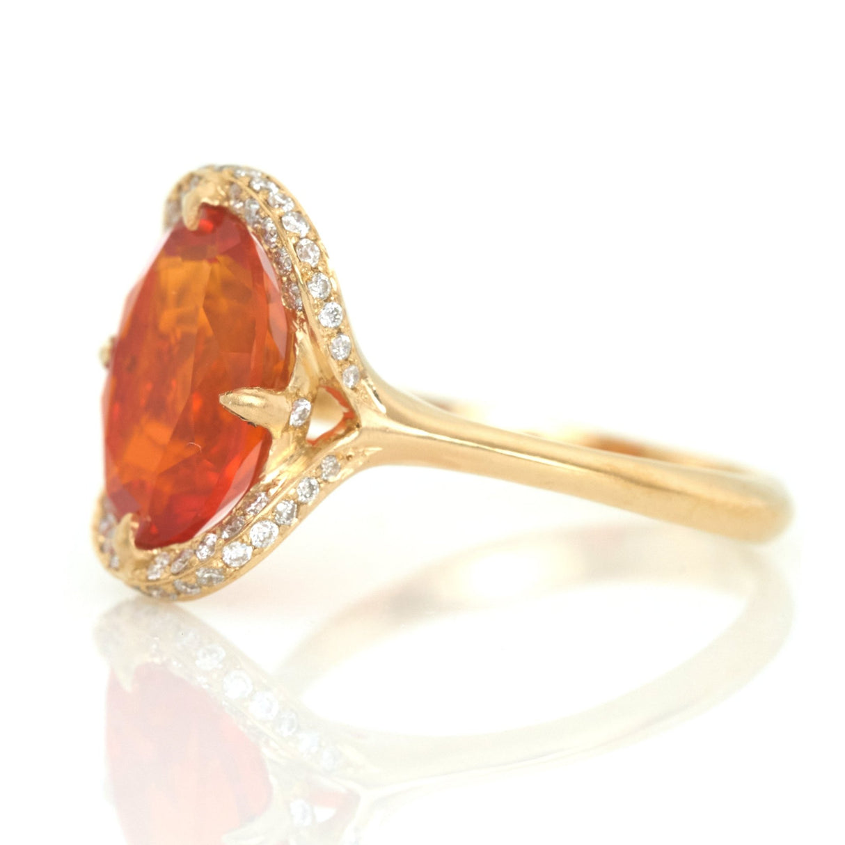 Orange fire opal 18k gold ring side view on white background.