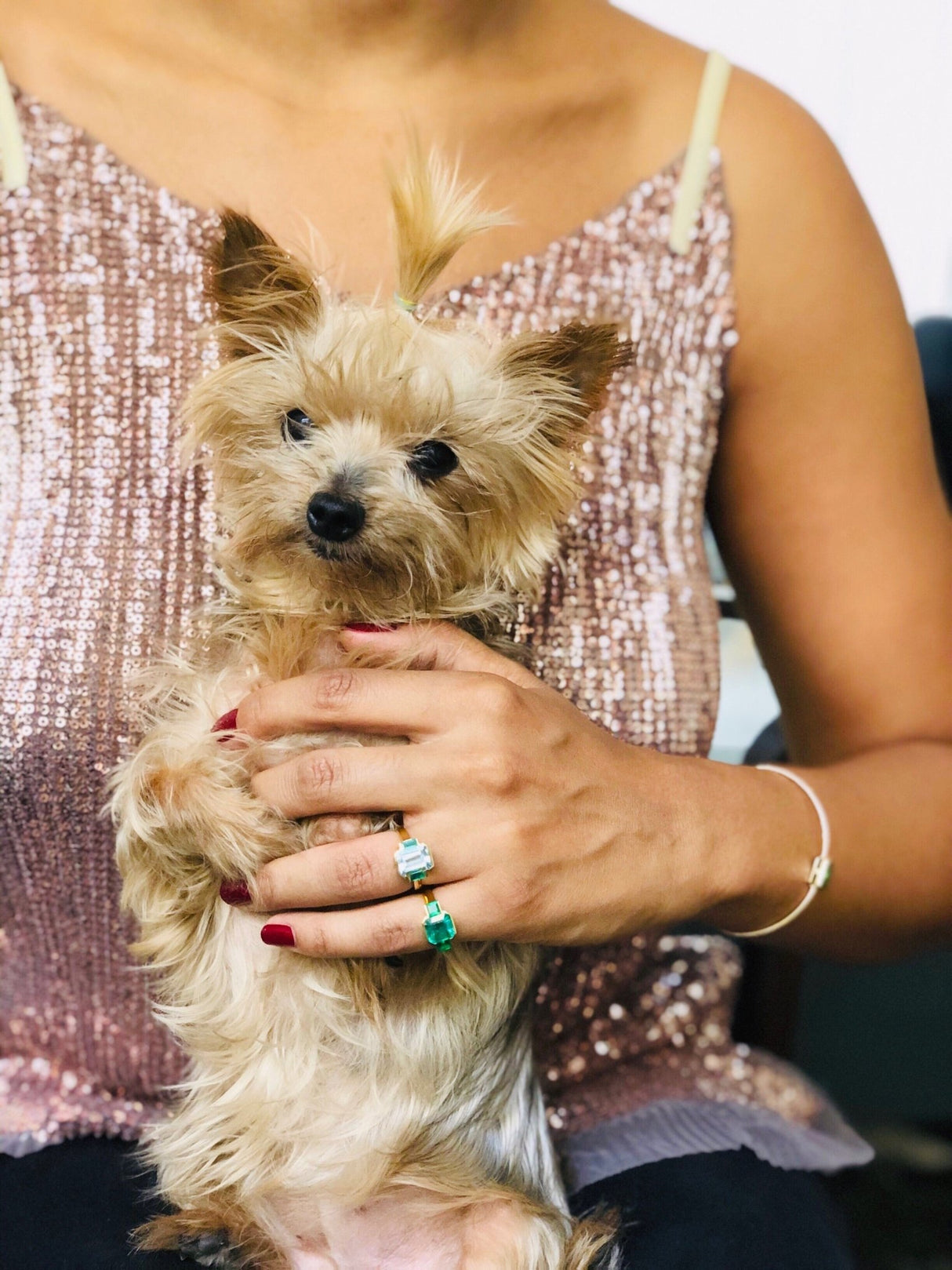 An 18K gold ring with a central aquamarine gem flanked by two vivid green emerald gems on the sides. Handmade by female artisans with sustainably mined gemstones. Exquisite and modern in design.