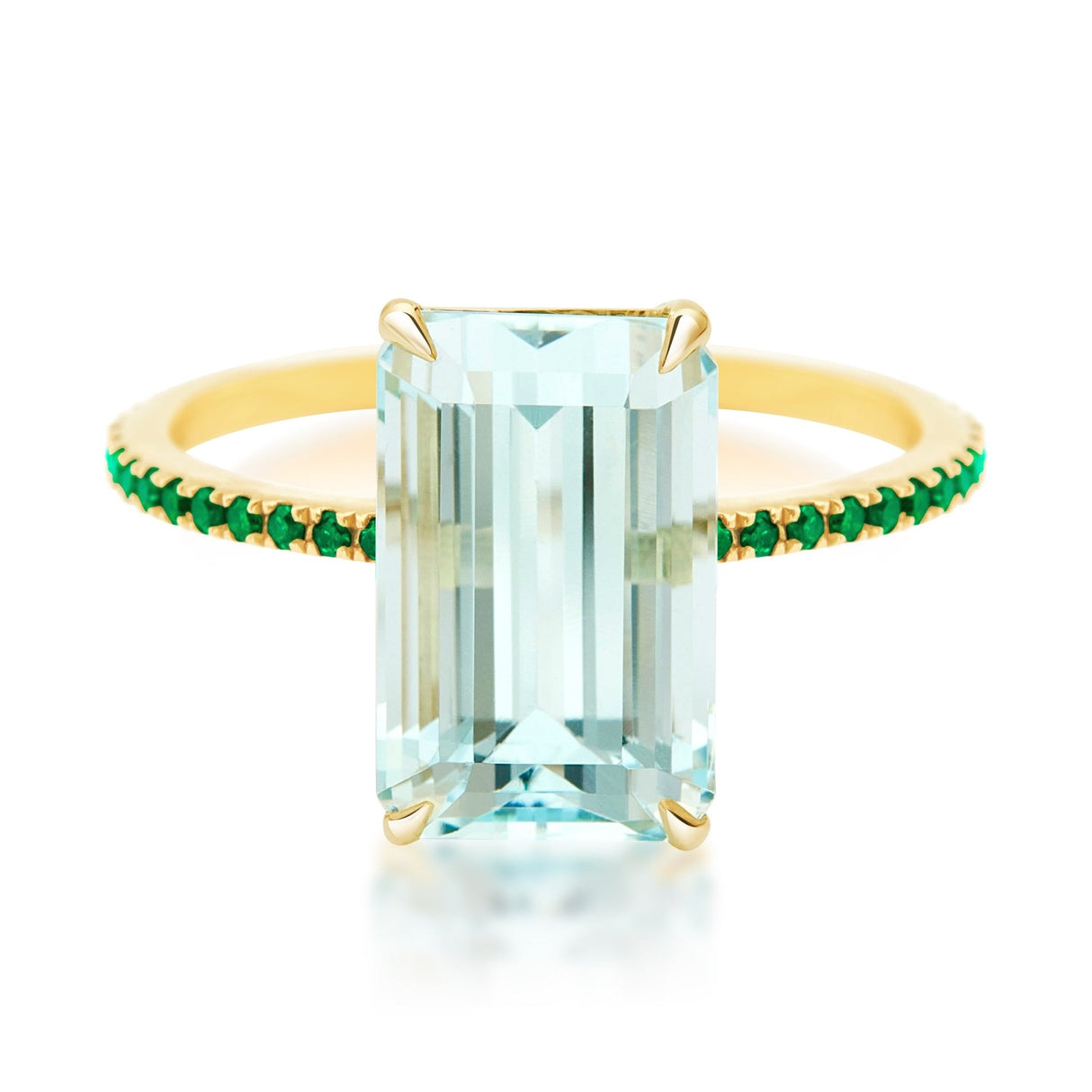 An 18K gold ring with a central aquamarine gem flanked by vivid green emerald gems on the sides. Handmade by female artisans with sustainably mined gemstones. Exquisite and modern in design.