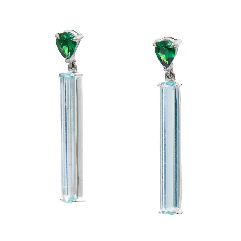 A pair of linear bar earrings featuring top green tsavorite and bottom clear aquamarine gemstones, set in platinum mounting. Handmade by female artisans with sustainably mined gemstones.
