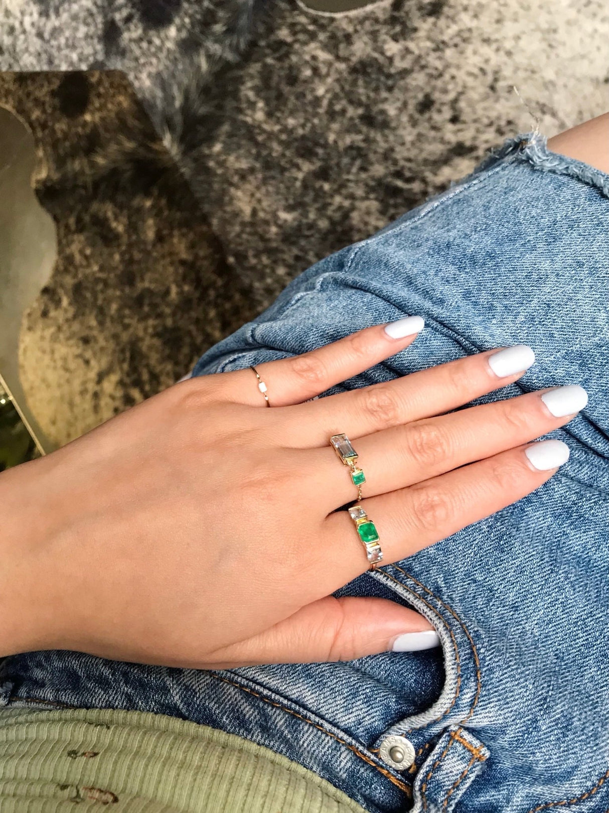 A gold ring featuring a central emerald triplet flanked by two aquamarines, with a linear chic silhouette. Handmade by female artisans with sustainably mined gemstones.