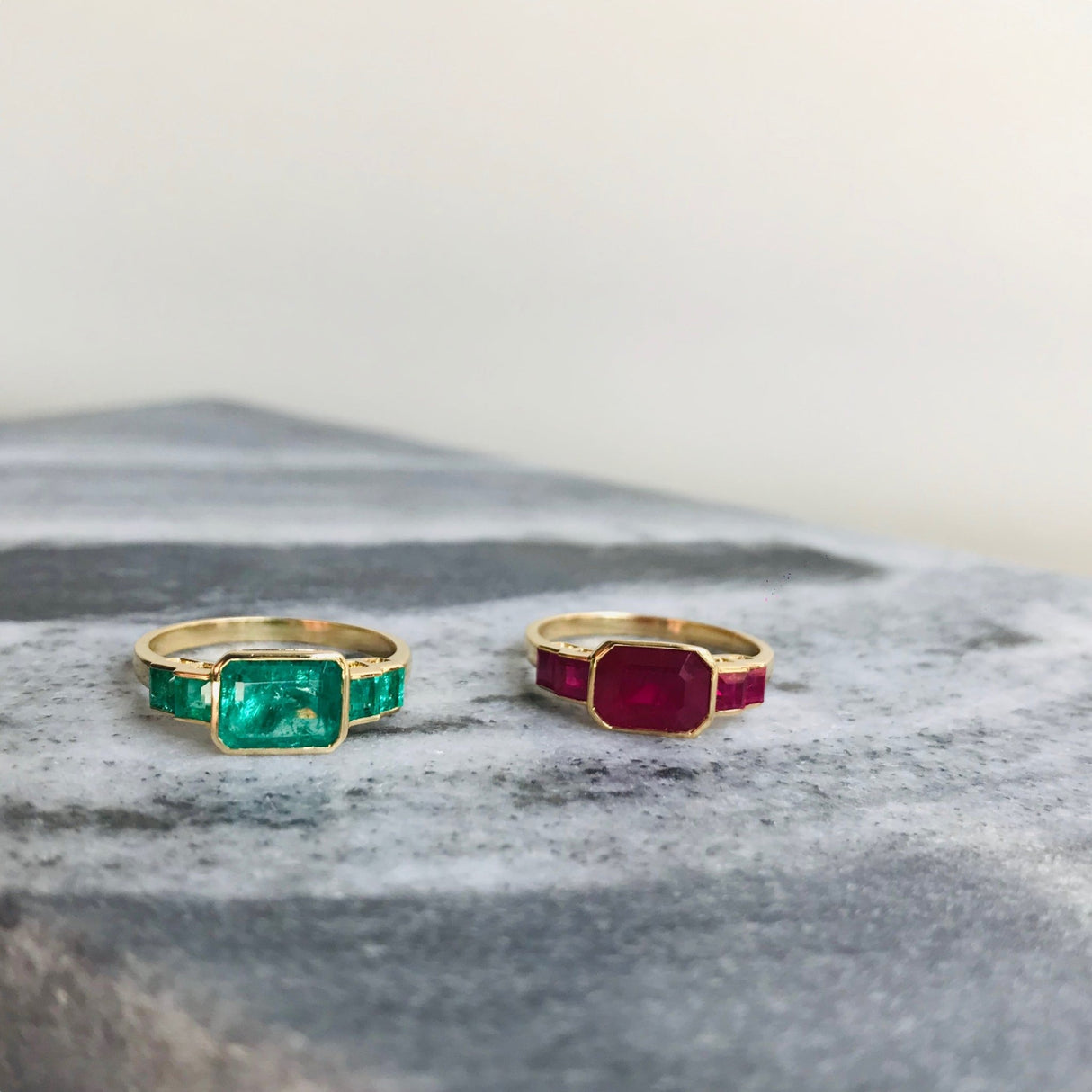 Emerald and Ruby rings on top a marble table