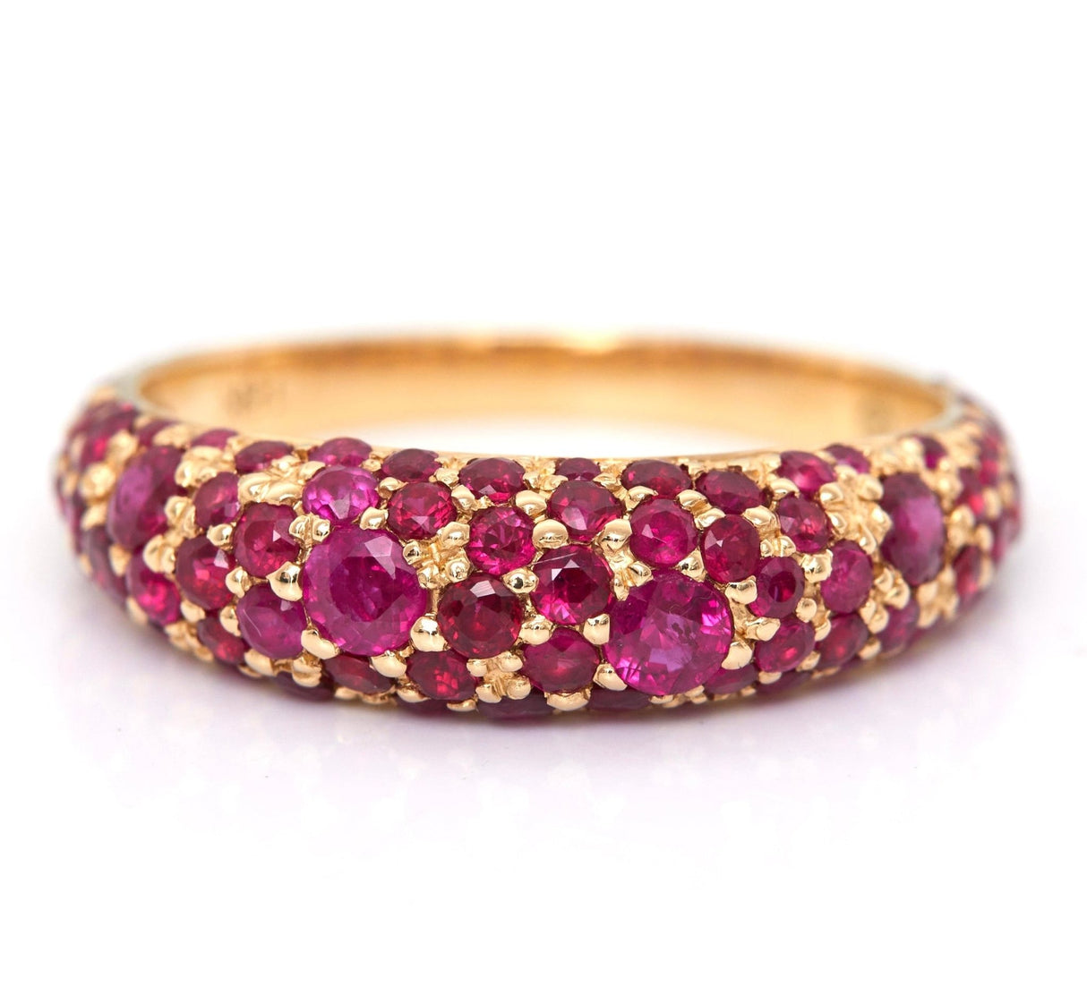 An 18k yellow gold ring with multiple round rubies set in a tight pattern.