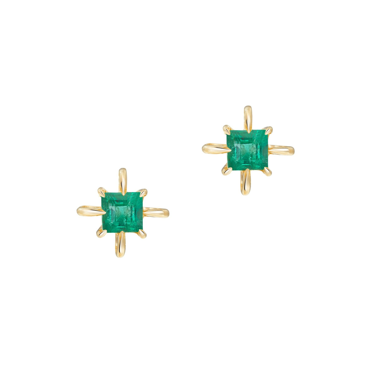 Gold earrings with green emerald gemstones on a white background