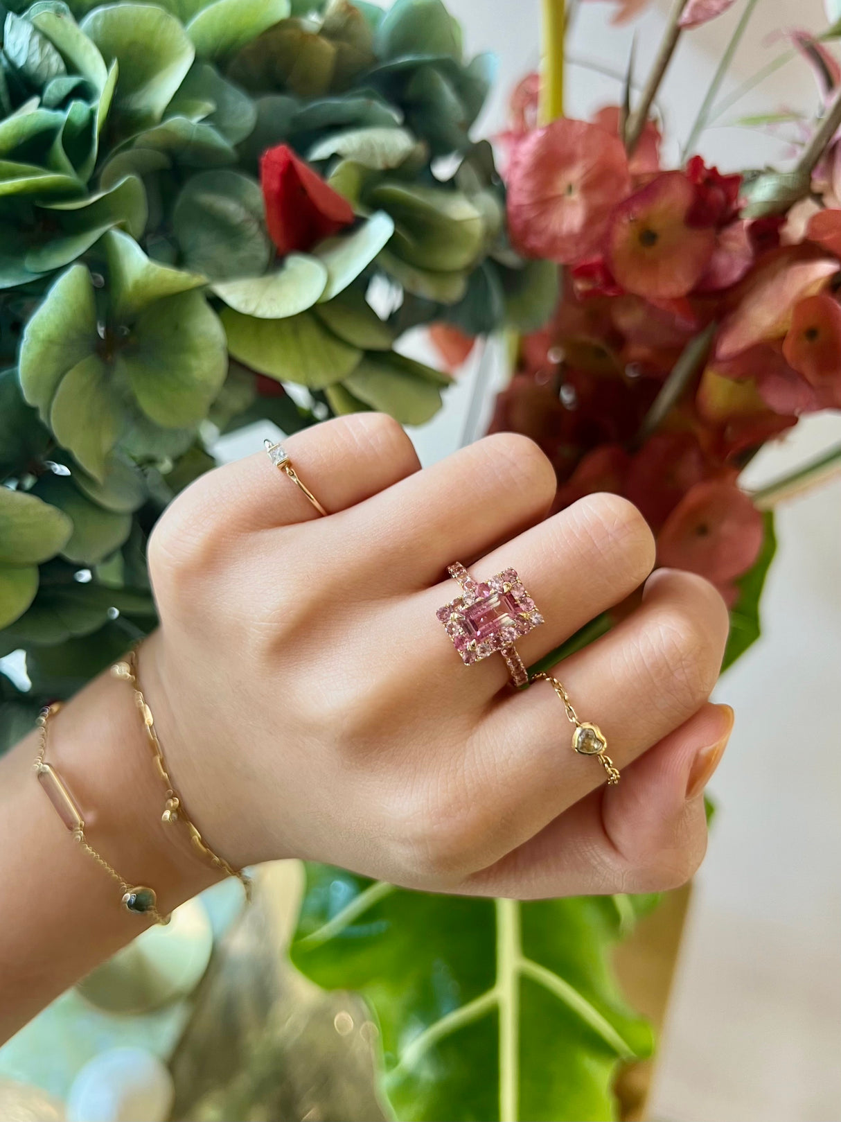 An ombré pink Tourmaline ring with a central, rectangular pink tourmaline surrounded by smaller pink tourmalines set in a gold band.