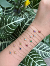 Many 14k gold gemstones in bracelet stack on arm by Yi Collection