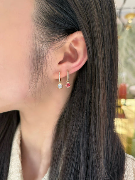 Close-up of a person wearing earrings with a blurred background