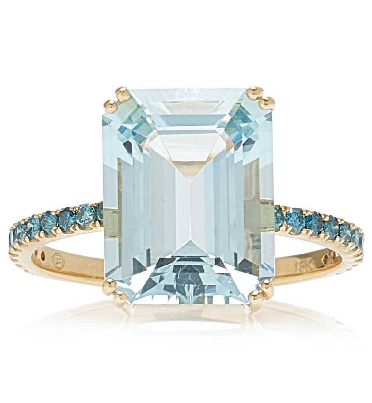 An 18K gold ring with a large emerald-cut aquamarine centerpiece and smaller blue diamond accents along the band.