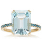 An 18K gold ring with a large emerald-cut aquamarine centerpiece and smaller blue diamond accents along the band.