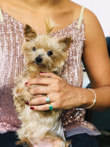 An 18K gold ring with a central aquamarine gem flanked by two vivid green emerald gems on the sides. Handmade by female artisans with sustainably mined gemstones. Exquisite and modern in design. 