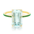 An 18K gold ring with a central aquamarine gem flanked by vivid green emerald gems on the sides. Handmade by female artisans with sustainably mined gemstones. Exquisite and modern in design. 