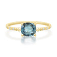 Gold ring with a blue gemstone on a white background