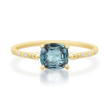 Gold ring with a blue gemstone on a white background