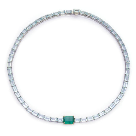 A necklace featuring a series of linked gemstones, with larger emerald cuts at the center and smaller aquamarine cuts on the sides, handmade by female artisans. Ethically sourced gemstones made into colorful wearable art. 