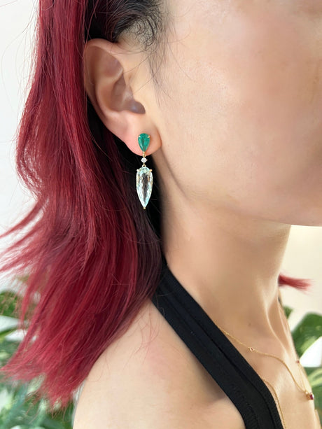 Emerald & Aquamarine Spring’s Dewdrop Earrings on model. Emerald & Aquamarine Spring’s Dewdrop Earrings. Exquisite handcrafted 18k earrings by female artisans in our Bangkok studio. Vivid green emerald paired with aquamarines from Madagascar and emeralds from Gemfields. Sustainably sourced and adds just the right pop of color. 