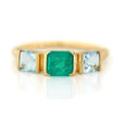 A gold ring featuring a central emerald triplet flanked by two aquamarines, with a linear chic silhouette. Handmade by female artisans with sustainably mined gemstones. 