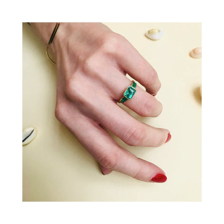 Vivid green emerald ring on a model’s hand