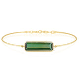 Gold bracelet with a green gemstone on a white background