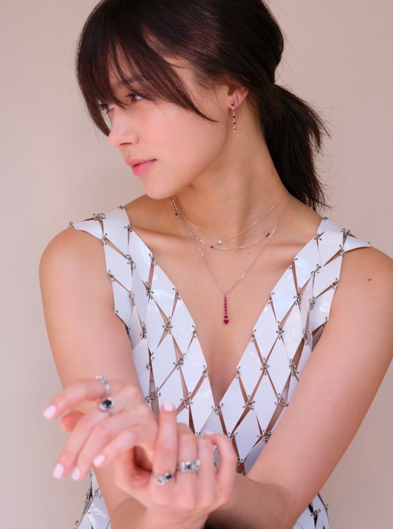 Model wears ruby links necklace in a stack of white gold necklaces on model 2