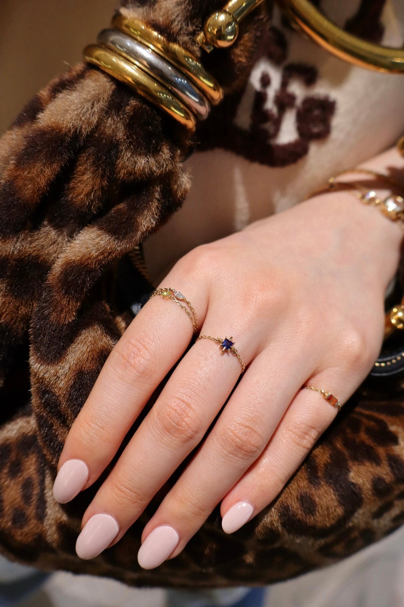 Hand with multiple rings on a leopard print background