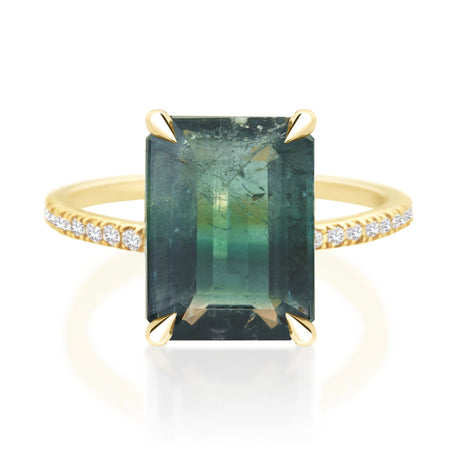 Ring with a green gemstone and gold accents on a white background