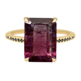 Gold ring with a large rectangular purple gemstone on a white background