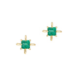 Gold earrings with green emerald gemstones on a white background