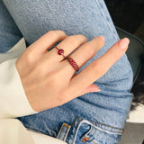 18k yellow gold ring with vivid red and pigeon blood red rubies on a model wearing jeans. Ruby rings stacked on a hand. 